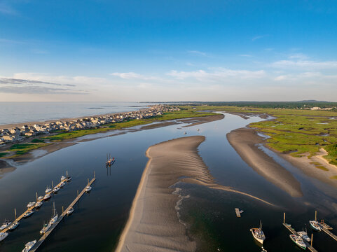 Aerial view of serene beach and calm ocean with fishing boats at low tide, Wells, United States.