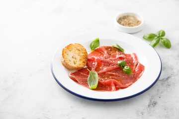 Traditional beef carpaccio with salt and pepper