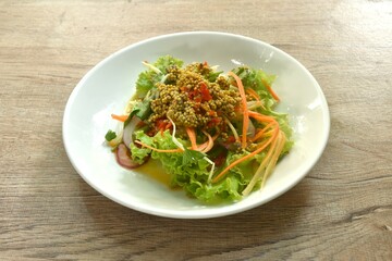 spicy and sour sea horseshoe crab egg wiith slice vegetable salad Thai food on plate