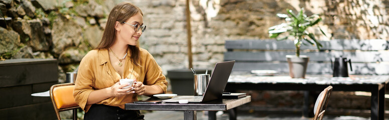 In a cozy cafe, a young woman sips coffee and works on her laptop, showcasing her vibrant daily life