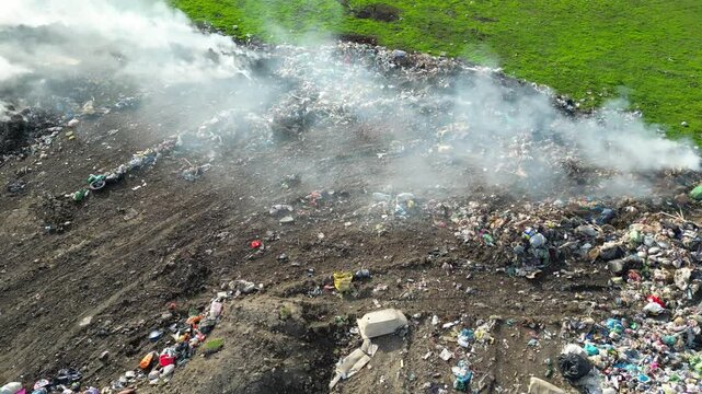 Aerial view of burning garbage dump pollution. Lot of smoke from the landfill near the city, environmental pollution. Drone shot of nature destruction, unhealthy life