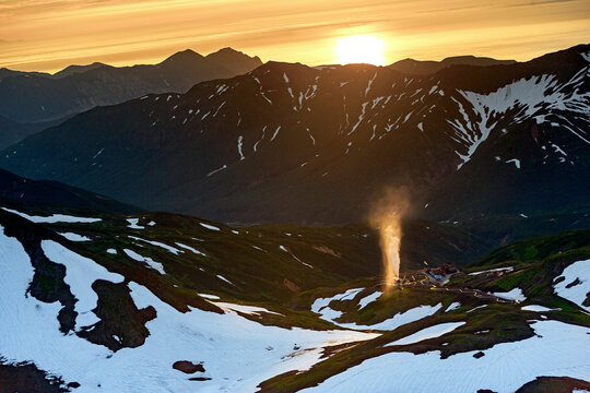 Aerial view of mutnovsky volcano at sunset surrounded by snow-capped mountains, Kamchatka, Russia.