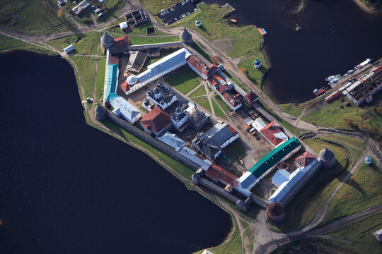 Aerial view of a historic fortress with stone walls and towers overlooking a tranquil lake, Onega Bay, Arkhangelsk Oblast, Russia.