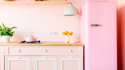 Pastel pink kitchen with retro fridge and wooden countertop