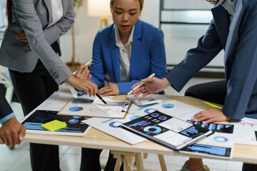 Business team analyzing financial data and discussing strategy in a meeting, working together on charts and graphs