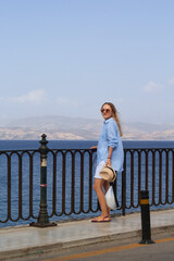 A young tourist woman explores the charming streets of Corfu’s old town, Kerkyra, Greece, enjoying the historic architecture and vibrant atmosphere.