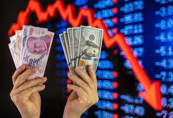 American dollar and Turkish lira on woman's hand and stock market screen, money chart background