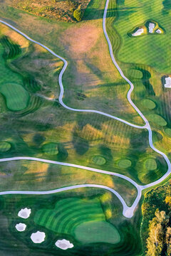 Aerial view of a beautiful golf course with fairways and sand traps surrounded by lush green trees, Nakhabino, Russia.