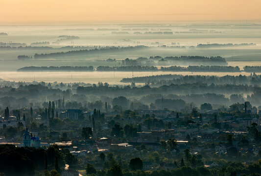 Aerial view of a serene cityscape surrounded by misty trees at dawn, Usman, Lipetsk Oblast, Russia.