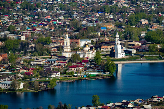 Aerial view of transfiguration cathedral with a picturesque river and quaint houses surrounded by greenery, Nevyansk, Russia.