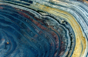 Aerial view of colorful pit mine with exposed layers and scarred terrain, Belgorod Oblast, Russia.