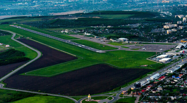 Aerial view of Belgorod International Airport surrounded by green countryside and urban development, Belgorod, Russia.