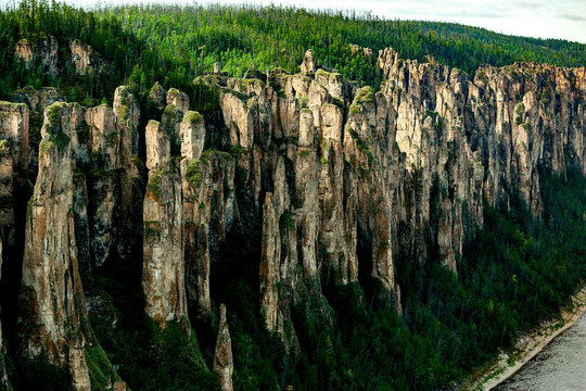 Aerial view of majestic lena pillars rock formations surrounded by serene forest and rugged cliffs, lena pillars national park, yakutia republic, russia.