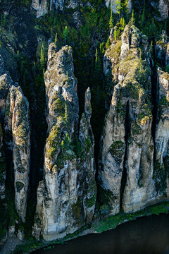 Aerial view of majestic rock formations and cliffs amidst serene forest and river, Lena Pillars National Park, Yakutia Republic, Russia.