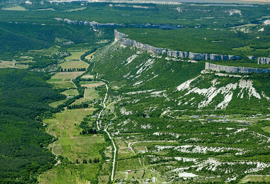Aerial view of the breathtaking Grand Canyon of Crimea with rugged cliffs and lush greenery, Bakhchysarai Raion, Russia.