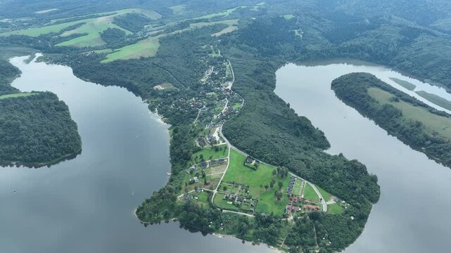 Drone flight in the mountains over a large headland separated by a lake. Mavic 3