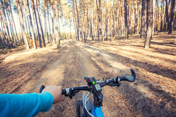 man cyclist rides in the forest on a mountain bike. first person view