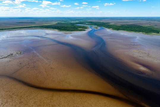 Aerial view of serene Onega Bay with tranquil water, lush forest, and expansive sky, Karelia Republic, Russia.