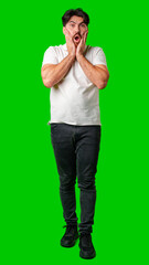 Young man expresses surprise in front of a bright green background