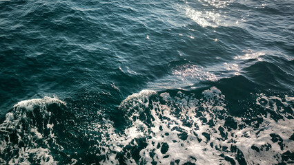 sea water with waves, white foam and reflection texture background