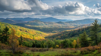Fototapeta premium A wide-angle view of a mountain range with rolling hills and forests in the foreground