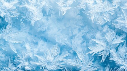 Obraz premium Frozen pattern on winter glass. Blue ice frost background, texture blue wallpaper. Crystals of snow on window surface. Screen overlay abstract design