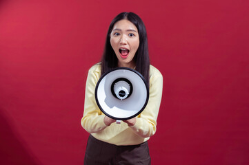 Asian woman with long black hair holding a megaphone in front, speaking enthusiastically while...