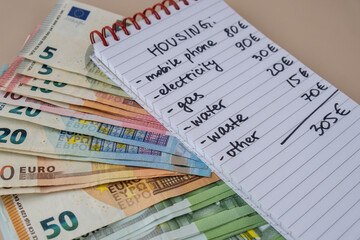 Euro cash money with notebook handwritten housing expenses. Counting bills for electricity, gas, water. Concept of Efficient Consumption and Economy