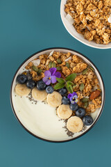 A healthy nutritious breakfast of natural Greek yoghurts, granola and fresh berries.