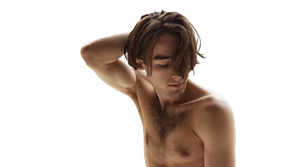 Obraz premium Shirtless male model with messy hair looks down in relaxed pose with his hand behind his head against white studio background. Concept of natural beauty, male health, fashion, skin care. Ad