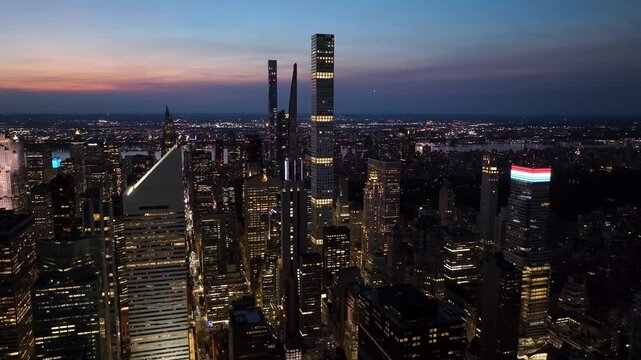 Aerial view of illuminated skyline and modern skyscrapers at night, New York City, United States.