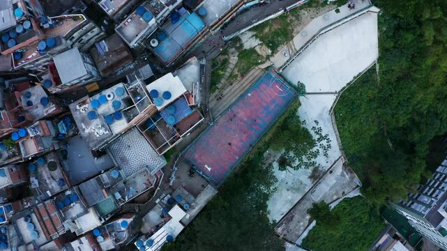 Aerial view of vibrant favela with people playing football among colorful rooftops, Rio de Janeiro, Brazil.