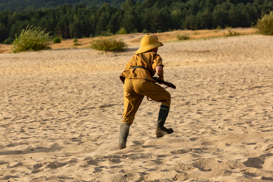 Reconstruction siege of Tobruk durind WWII. Italian infantry soldier attack enemy positions in the desert. View from behind. Błęd&oacute;w desert, Silesia, Poland