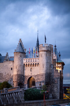 Het Steen, Antwerp, Belgium, August 17th, 2007, A majestic stone castle with fluttering flags under an overcast sky, showcasing its rich historical architecture