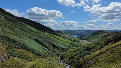 Scenic view of lush green hills and a distant lake.