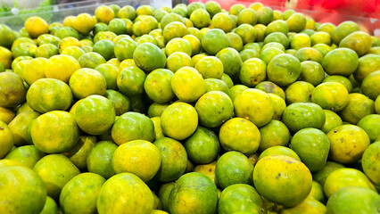 A vibrant, overflowing display of fresh green oranges, ripe and ready. Perfect for healthy eating, juice, or culinary creations. 