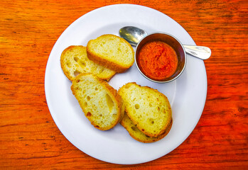 Meal in restaurant plate with bread toast bun and hot sauce.