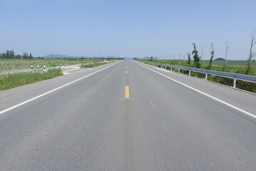 Photograph of a straight road during daytime, used as an illustration.