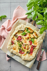 Puff pastry tart pizza with tomatoes, mozzarella cheese and pesto sauce. Galette Caprese