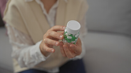 A middle-aged woman holding a pill bottle indoors focusing on medication and healthcare at home