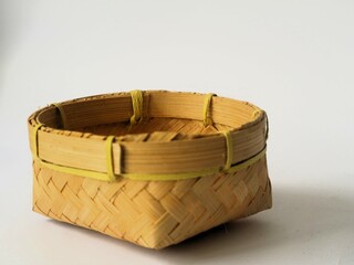 Obraz premium Indonesian traditional besek or a food container made of woven bamboo isolated white background. DIY food container usually used for traditional event