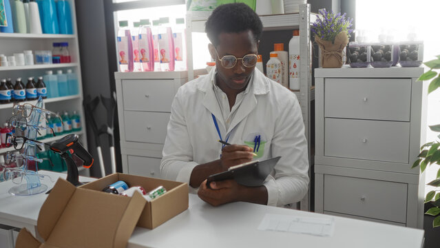 Young, african, american, man, in, pharmacy, store, writing, on, clipboard