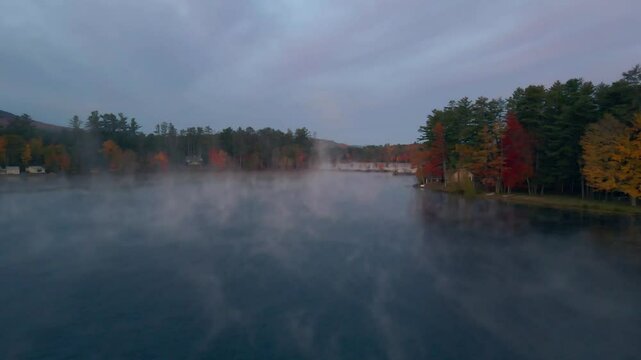 Aerial view of serene North Pond surrounded by tranquil autumn foliage and misty forest, Bethel, United States of America.