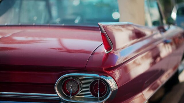 Close up of the side of a burgundy, retro car parked on the street