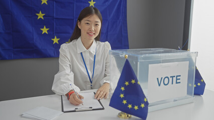 A young asian woman staffs a voting station indoors with european union flags, emphasizing...