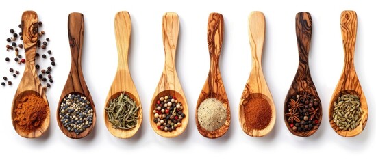 A variety of spices in a wooden spoon set against a white background offering ample copy space in a top down flat lay composition