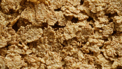 Closeup image of corn flakes cereal suitable for breakfast scenes, showcasing brown and crispy flakes with textured detail
