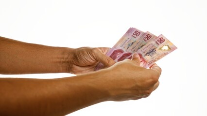 Hands holding mexican pesos over a white isolated background showcasing money counting and financial concepts.