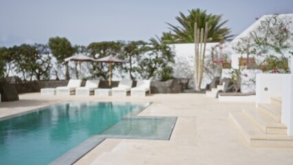 Blurred tropical resort with empty poolside chairs and lush greenery in the background, evoking a tranquil vacation ambiance