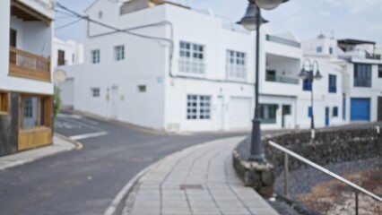 Blurred outdoor scene of lanzarote street in spain, showcasing bokeh effect with a defocused background of typical canary islands architecture and street lamps.